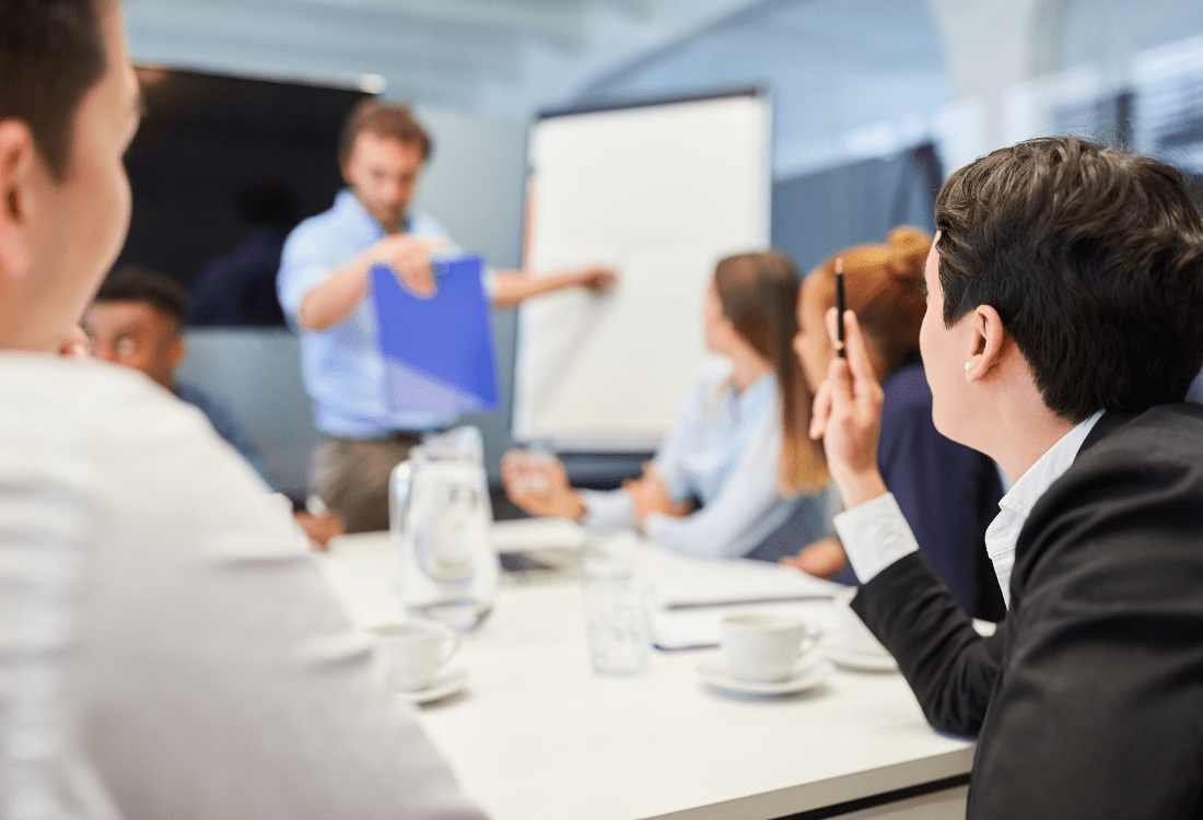 Team development consultant facilitating strategic meeting with business executives around conference table.